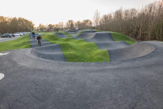 Kinder und Jugendliche fahren mit ihren Fahrrädern über einen asphaltierten pump track, Nordrhein-Westfalen, Deutschland, Weilerswist