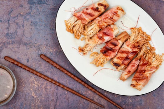 Bacon rolls stuffed with enoki mushroom. Bacon wrapped mushroom. Flat lay with copy space.