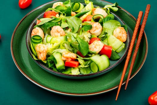 Plate with salad of fresh vegetables, herbs and shrimp. Prawns salad. Top view.