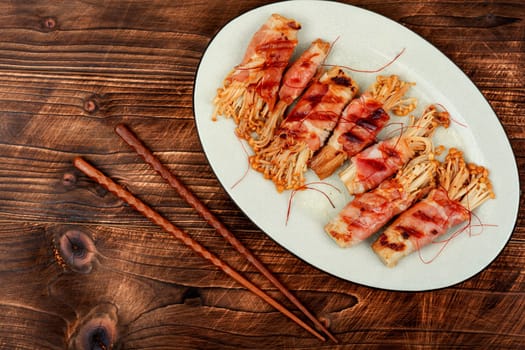 Bacon rolls stuffed with enoki mushroom. Bacon wrapped mushroom. Flat lay with copy space.