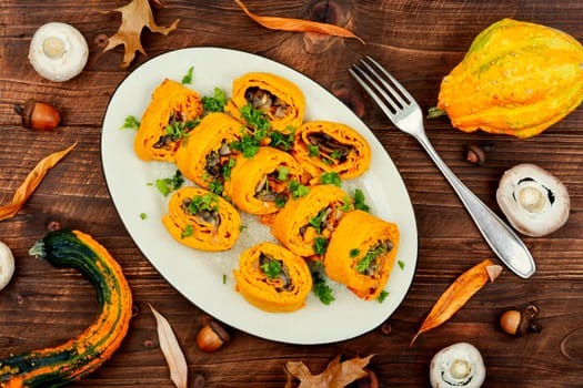 Delicious pumpkin dough rolls stuffed with mushrooms on vintage table.