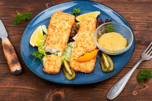 Fish fillet roasted in bread crumbs and with kiwi. Top view.
