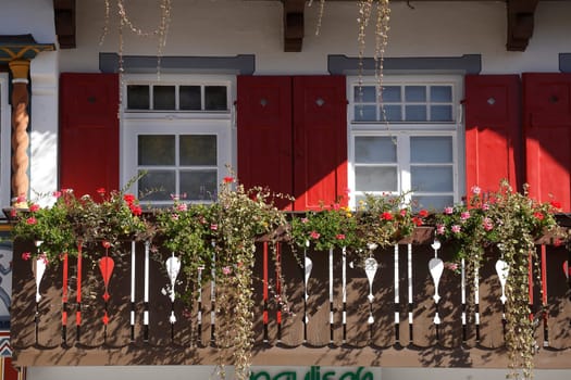 Balcony with flower boxes, windows and red shutters, Garmisch-Partenkirchen, Upper Bavaria, Bavaria, Germany