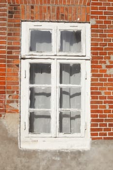 Old, white wooden window on a red brick wall, Germany