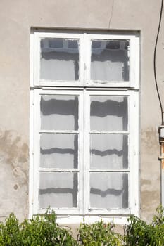 Old, white wooden window on a white house wall, Germany
