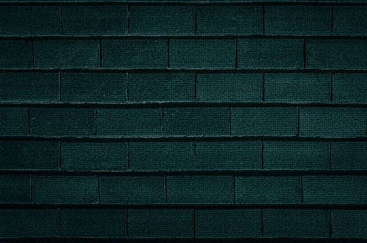 The background texture of an old rough brick wall is dark green in close-up