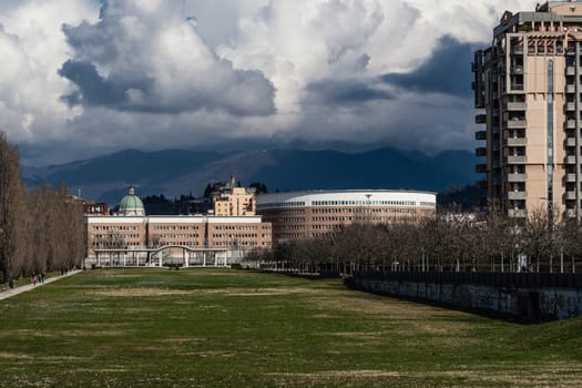 A panoramic view of the Tarello Park in Brescia (Italy) and the city skyline in the background with the Palace of Justice, the cathedral dome and the medieval castle on top of the hill. Overcast sky on a winter day.
