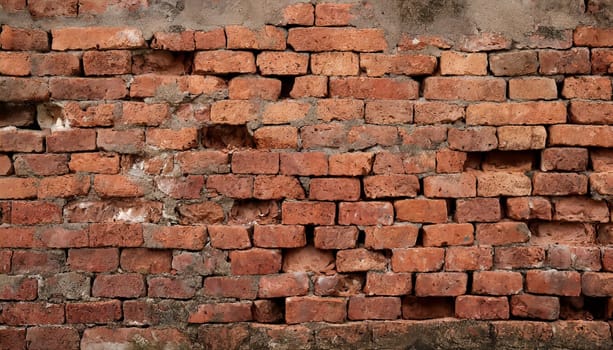 Fragment of old brickwork, close-up. Red brick wall. Potholes and defects in a brick wall. Flat lay, close-up. Cracks and defects of red brick on the wall. building houses, texture