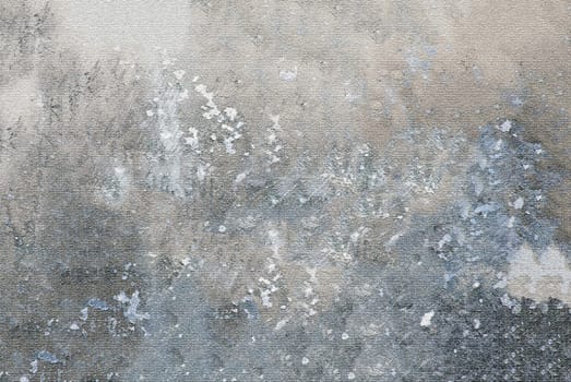 The texture of a gray old rough wall with spots and irregularities on the surface in close-up