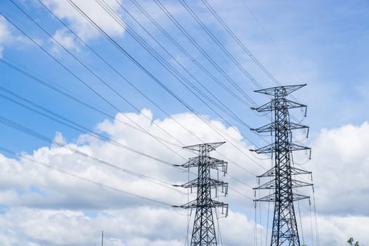 High voltage power line and pylon on blue sky