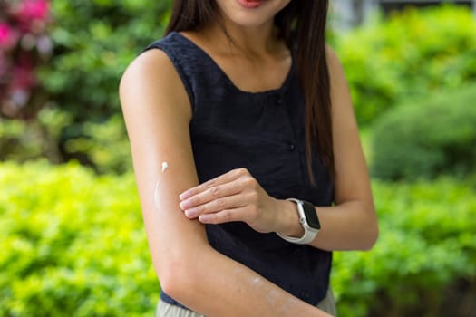 Woman apply sun block on the hand at park