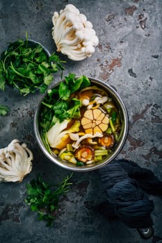 Beef and miso garlic broth, soup with vegetables, mushrooms and cilantro in a pot