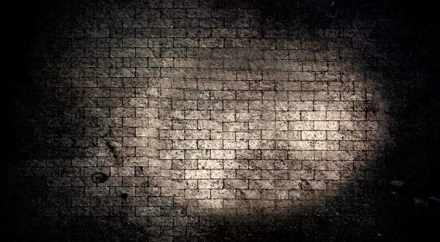 The texture or background of a dark old brick wall with scuffs and darkening at the edges and an enlightened center for the text