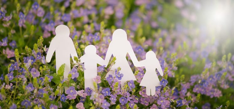 Parents with children walking on a meadow and holding hands, relationship in family, care and security concept, charity and insurance