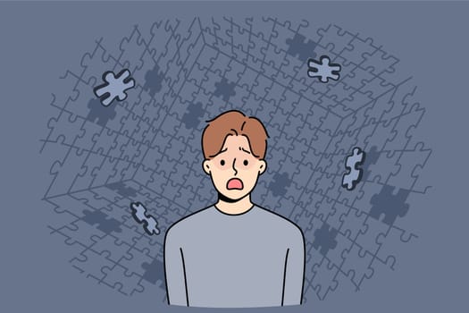 Depressed man screams during panic attack or hallucination, standing among collapsing puzzle. Guy with personality disorder needs help psychologist to get rid panic attacks and restore mental health