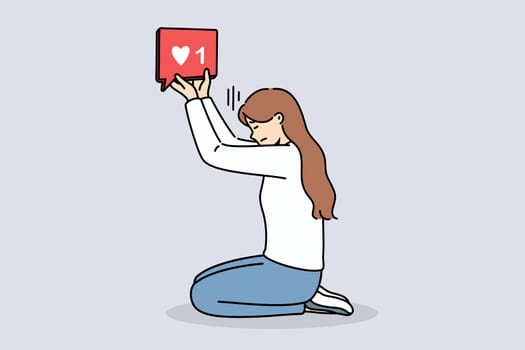 Woman blogger holds like icon, kneeling and dreaming of receiving lot of feedback from subscribers on social networks. Girl blogger suffering digital addiction needs constant approval followers