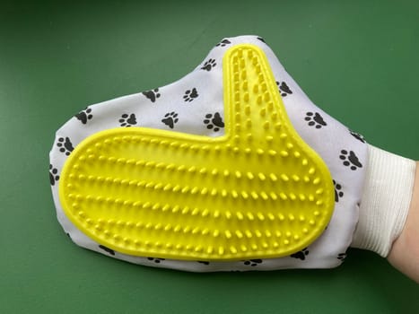 Using a glove to the remove cat hair from the carpet