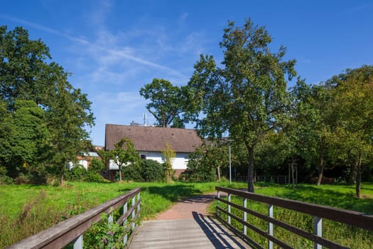 Pedestrian bridge with path in a green area and residential buildings, Wunstorf, Lower Saxony, Germany