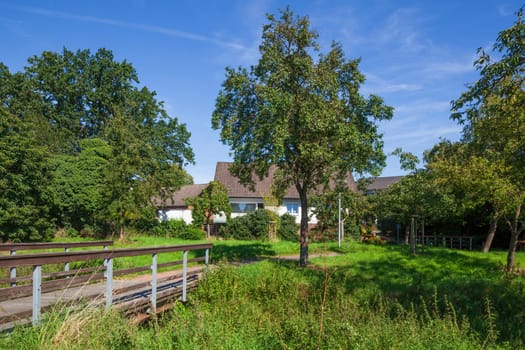 Pedestrian bridge with path in a green area and residential buildings, Wunstorf, Lower Saxony, Germany