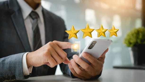 close up on customer man hand pressing on smartphone screen with gold five star rating feedback icon and press level three rank (good) for give score point to review the service business concept