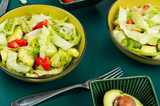 Green vegan salad made from a mixture of green leaves and vegetables. Top view.