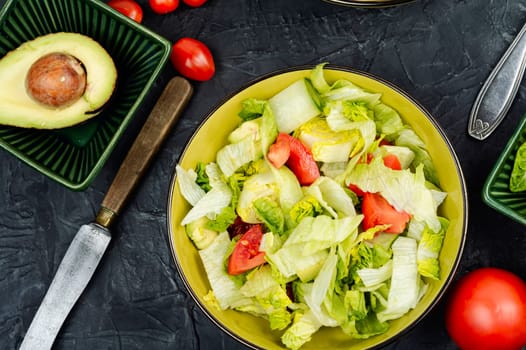 Green vegan salad made from a mixture of green leaves and vegetables. Top view.