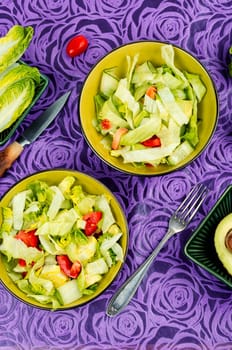 Green vegan salad made from a mixture of green leaves and vegetables. Top view.