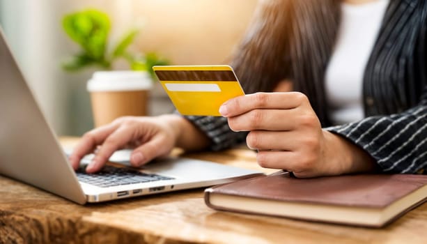Close-up of a person using a credit card for an online purchase on a laptop, highlighting convenient digital transactions