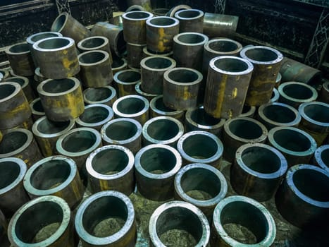 many thick-walled iron pipe chunks sawn on a band saw.
