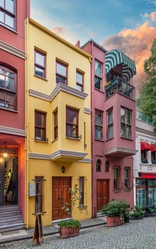Facade of colorful residential buildings painted in red and yellow, at cobblestone alley suited in Kuzguncuk neighborhood, Uskudar district, Istanbul, Turkey