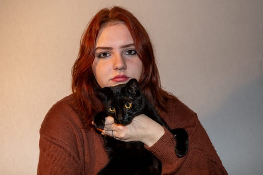 A girl with her black cat and white background
