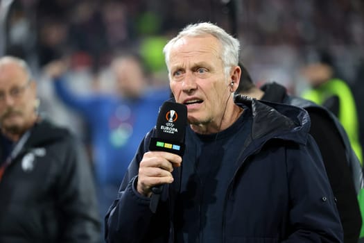 Coach Christian Streich (SC Freiburg) on his way to a TV interview ahead of the Europa League match - Round of 16: SC Freiburg vs West Ham United