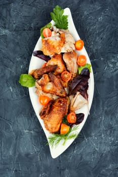 Sliced baked grilled chicken with cherry tomatoes on a plate. Space for text.