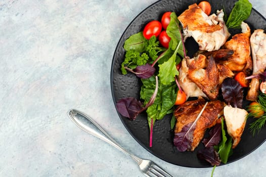 Sliced baked grilled chicken with cherry tomatoes on a plate. Space for text.