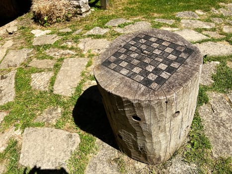 Outdoor stump chess or checkerboard in the recreated and restored 1800 Pioneer Village at Spring Mill State Park, near Mitchell, Indiana USA.