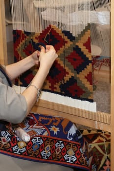 A woman making a rug