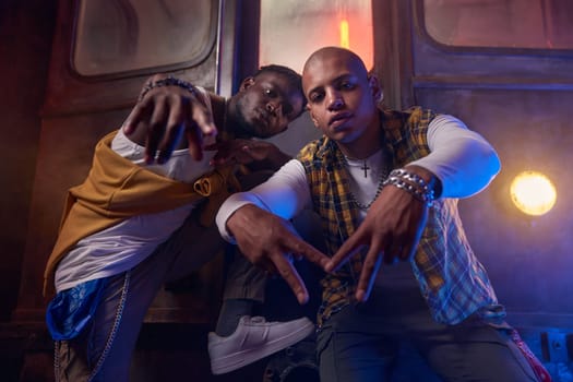 Two emotional guys performing hip-hop style in underground. Young people crazy about rap