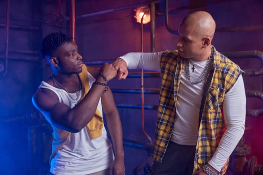 Two young confident junior gang members giving fist welcoming each other. Dangerous criminal society concept