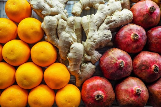 Oranges, ginger and pomegranate displayed at street market in Morocco, closeup detail