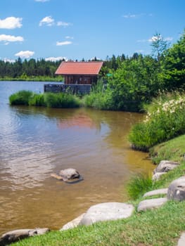 Landscape view with small swimming area and small fisherman's house on Bavarian Attlesee near the town of Nesselwang. ​