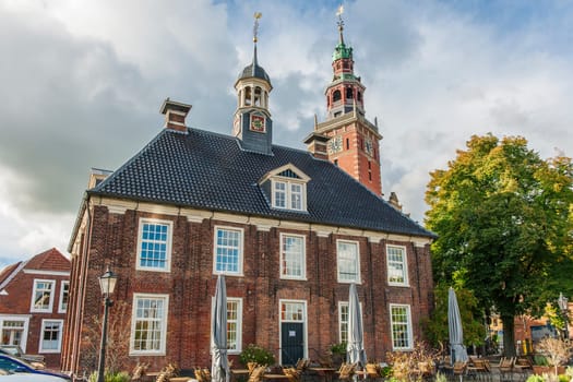 Leer, Germany - September 28, 2022: Traditional architecture with the old scales in the foreground and the town hall tower protruding above it.