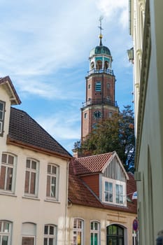Bell tower of the large Reformed church in East Frisia in autumn 2022 in sunny weather with light veiled clouds.