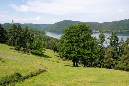 Landscape with a view of Lake Edersee with trees, blue sky and clouds, in Hesse, Germany