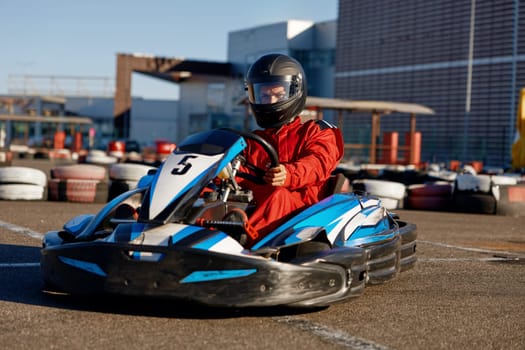 Kart pilot ready to start championship in outdoor go-karting circuit. Tournament entertainment for extreme sports driver