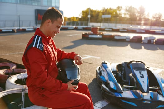 Frustrated go-cart racer loser in sportswear feeling sad and despair after lost in tournament at motor track outdoors