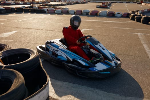 Diver racing on go-cart track outdoors enjoying competitive activity. Carting recreational pursuit challenge