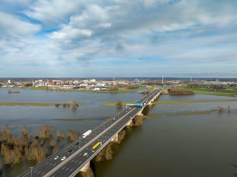 DEVENTER, NETHERLANDS - MARCH 2, 2024: A1 (E30) highway over the IJssel river seen from the air. It is the main east-west connection between Germany and West Netherlands.