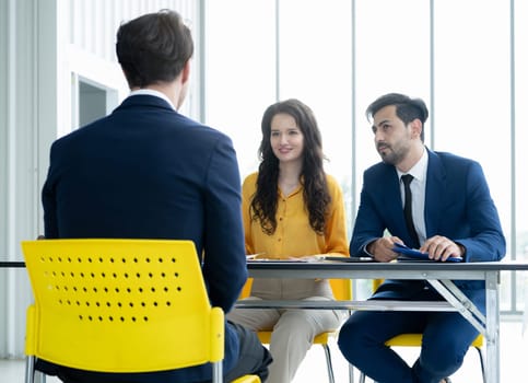 Job interview concept. Diverse hr team doing job interview with a man in business office. Human resources team interviewing a potential job candidate. Hiring, employment, and recruitment concept.