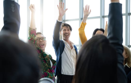 A group of people are smiling and waving at the camera. Scene is happy and celebratory