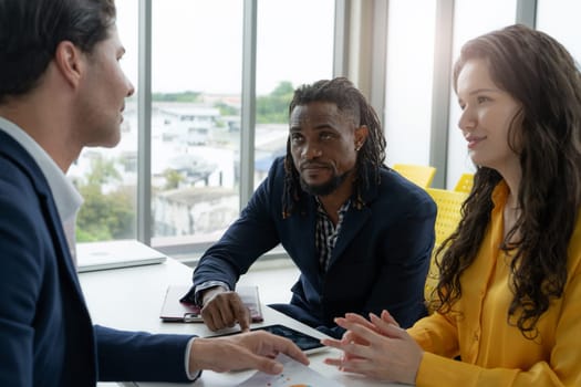 A man and a woman are sitting at a table with a man in a suit
